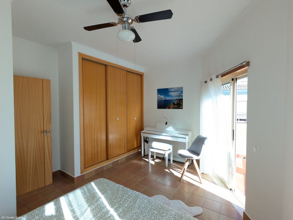 Fitted cupboard and electric piano in the bedroom